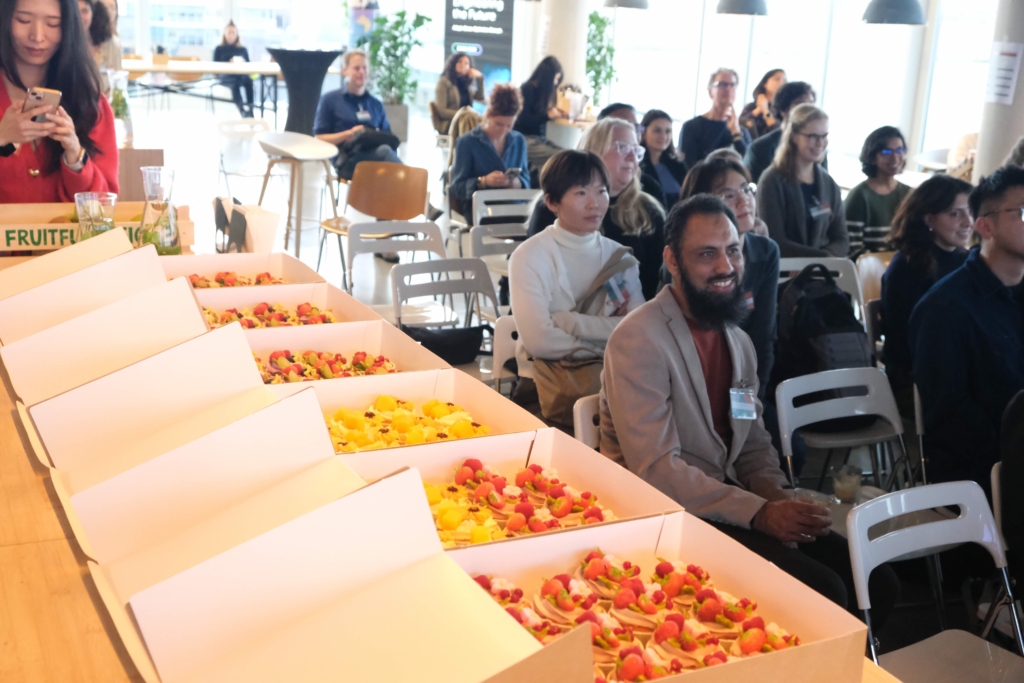 Six boxes of Cake Researcher decorated cakes next to audience